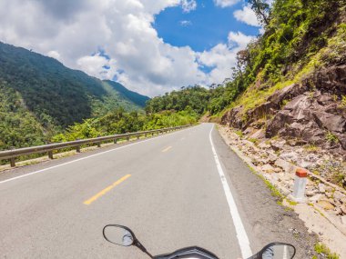 Bulutlu bir havada, yılanlı bir yolda motosiklet sürüyor. Vietnam, Dalat