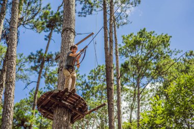 Macera halat parkında güvenlik ekipmanlarıyla çekici bir genç.