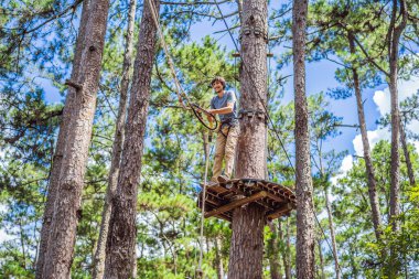 Macera halat parkında güvenlik ekipmanlarıyla çekici bir genç.