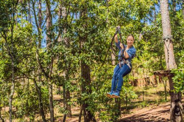 Macera halat parkında güvenlik ekipmanlarıyla genç çekici bir kadın.