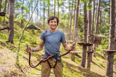 Macera halat parkında güvenlik ekipmanlarıyla çekici bir genç.