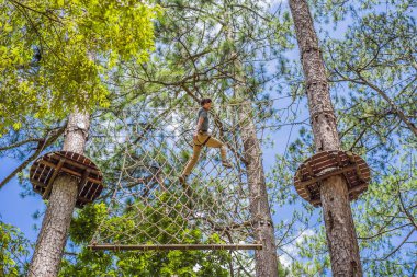 Macera halat parkında güvenlik ekipmanlarıyla çekici bir genç.