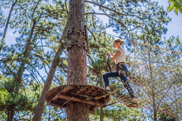 Junge attraktive Frau im Abenteuer-Seilpark in Sicherheitsausrüstung — Stockfoto