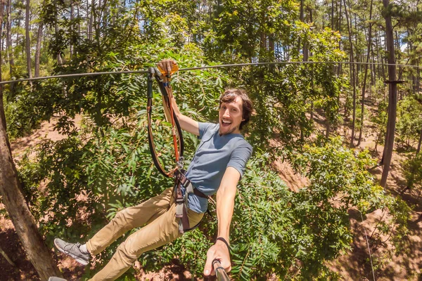 年轻迷人的男子在冒险绳公园的安全设备 — 图库照片
