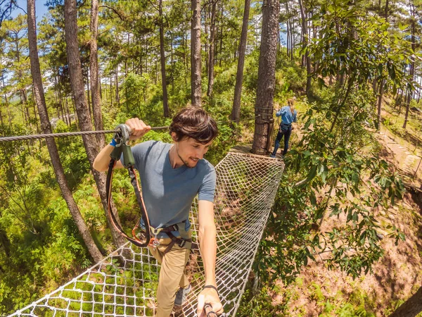 Jovem atraente homem e mulher no parque de corda de aventura em equipamentos de segurança — Fotografia de Stock