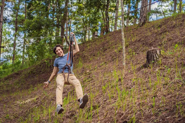 stock image Young attractive man in adventure rope park in safety equipment