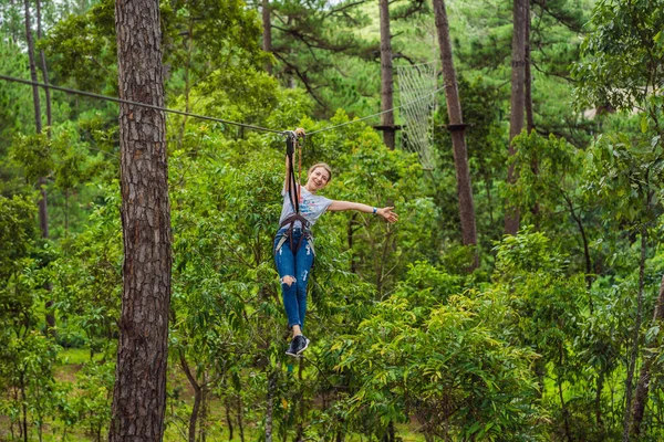 Junge attraktive Frau im Abenteuer-Seilpark in Sicherheitsausrüstung — Stockfoto