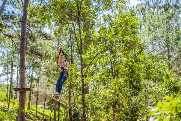 Junge attraktive Frau im Abenteuer-Seilpark in Sicherheitsausrüstung — Stockfoto