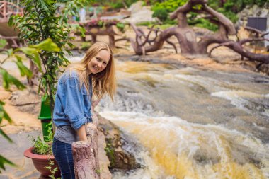 Anne ve oğlu yazın Dalat, Vietnam 'da şelale manzarasının arka planında.