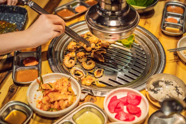 Egy nő grillezett grillsütőt a széntüzes grillsütőn. Koreai vagy japán hagyományos élelmiszer grillezés stílus barbecue — Stock Fotó