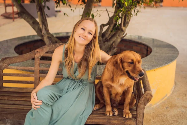 Mujer joven acariciando un lindo perro esponjoso — Foto de Stock