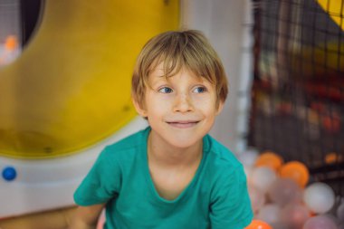 Çocuk kapalı bir parkta eğleniyor.