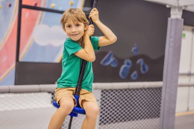 Çocuk kapalı bir parkta eğleniyor.