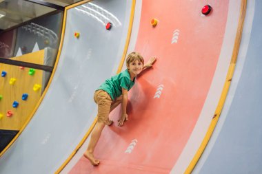 Çocuk kapalı bir parkta eğleniyor.