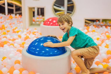 Çocuk kapalı bir parkta eğleniyor.