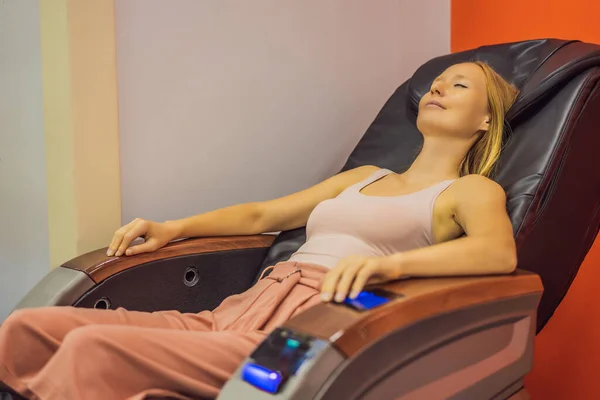 Piękna młoda kobieta relaksująca się na krześle do masażu na lotnisku lub w centrum handlowym — Zdjęcie stockowe