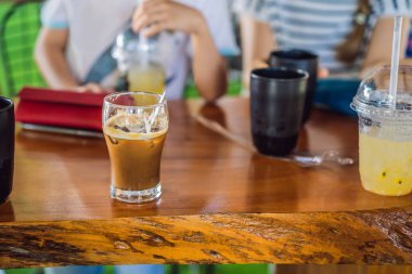 Tahta bir masada bir bardak soğuk kahve.