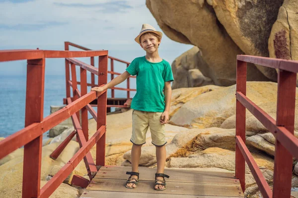 Niño en el paseo marítimo con escaleras a la playa, concepto de vacaciones —  Fotos de Stock