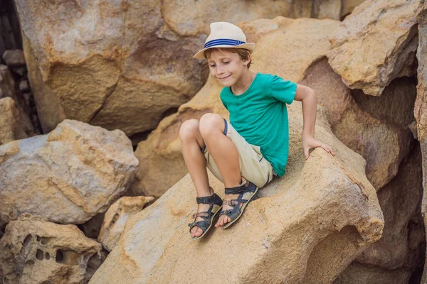 Молодой мальчик лазает по скале, концепция отпуска — стоковое фото
