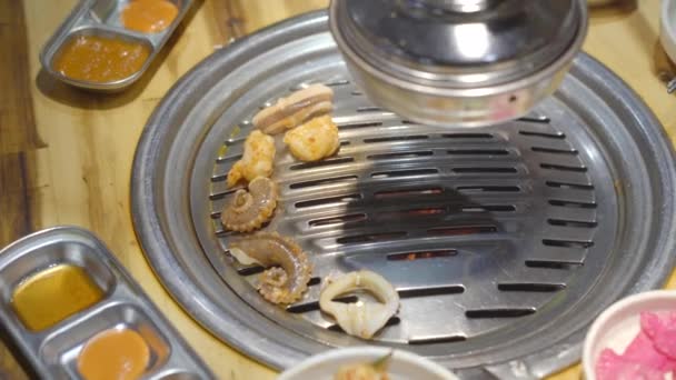 Family visits a Korean grill restaurant where you can cook your own food. Travel to Korea concept — Stock Video