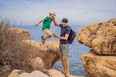 Baba ve oğlu bir kayanın üstünde. Yurtiçi tatil kavramı