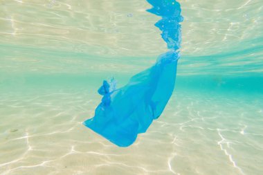 Yaratıcı bir altyapı, okyanusta yüzen plastik torba, suda bir torba. Çevre kirliliği kavramı, ayrıştırılamayan plastik, dünya okyanuslarındaki artışlar.