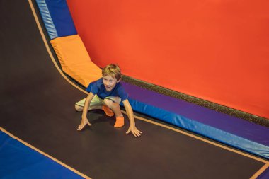 Eğlence merkezinde trambolinde zıplayan tatlı çocuk.
