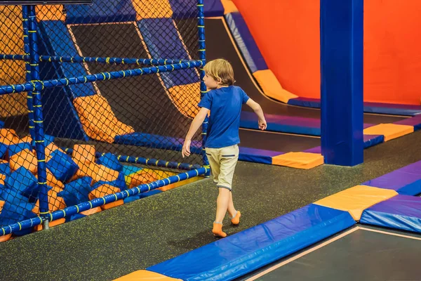 Mignon garçon sautant sur trampoline dans le centre de divertissement — Photo