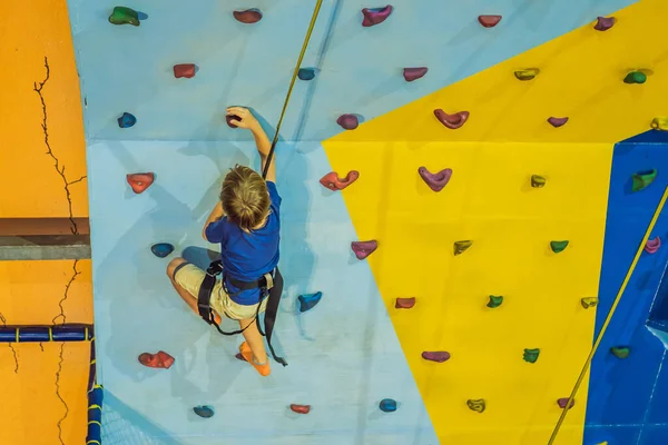 Niño de 6 años trepando en una pared en un centro de escalada —  Fotos de Stock