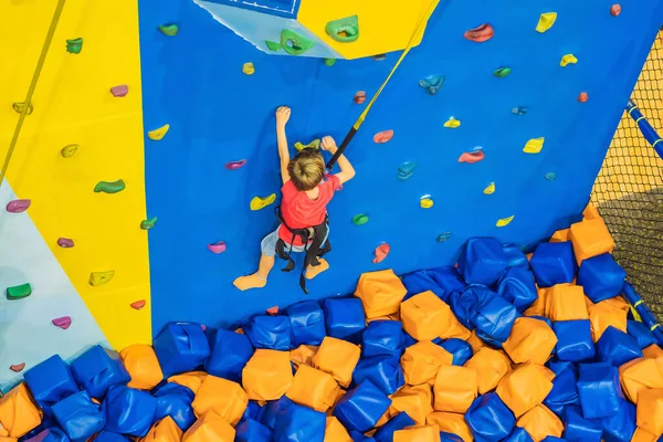 Niño de 6 años trepando en una pared en un centro de escalada — Foto de Stock