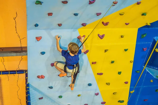 Niño de 6 años trepando en una pared en un centro de escalada — Foto de Stock
