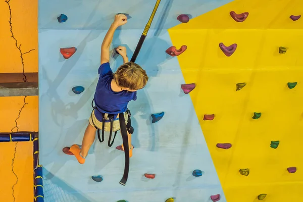 6-летний ребенок лазает по стене в альпинистском центре — стоковое фото