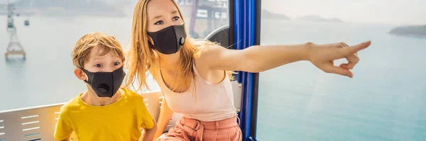 BANNER, LONG FORMAT Mother and son wearing a hygiene protective mask over her face while ride a cable car. Healthcare and sickness prevention from coronavirus, Covid19 influenza in crowded place — Stock Photo, Image