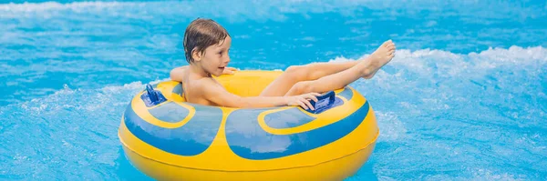 Хлопчик на плаву на штучних хвилях у аквапарку BANNER, LONG FORMAT — стокове фото