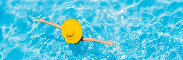 Mujer sentada en una piscina en un gran sombrero amarillo BANNER, FORMATO LARGO —  Fotos de Stock