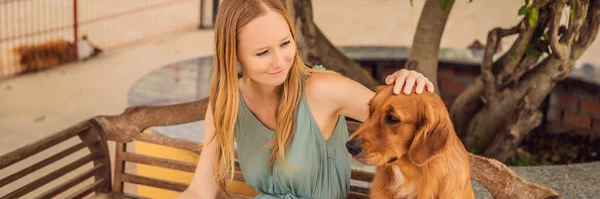 Genç bir kadın tüylü, sevimli bir köpeği okşuyor. — Stok fotoğraf