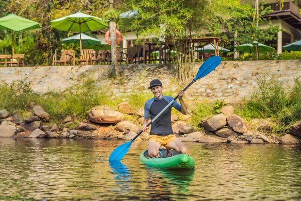 Vreugdevolle man traint SUP board in de rivier op een zonnige ochtend. Stand up paddle boarding - geweldige actieve outdoor recreatie — Stockfoto