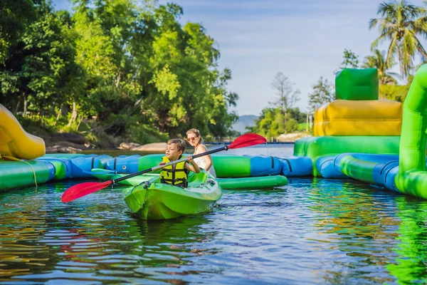 Niño feliz sosteniendo remo en un kayak en el río, disfrutando de un hermoso día de verano — Foto de Stock