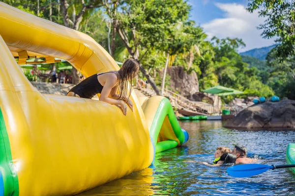 Frau durchläuft aufblasbaren Hindernisparcour im Pool — Stockfoto