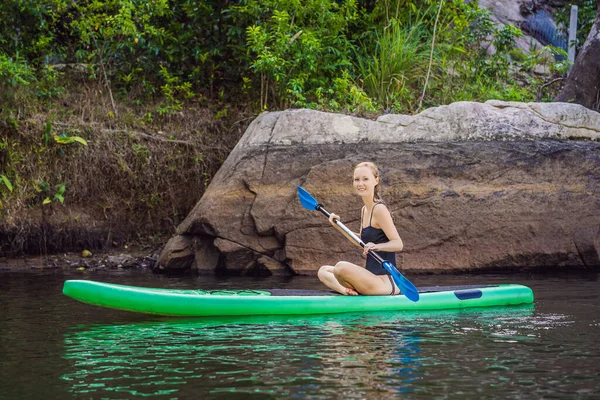 Widok z boku zdjęcie kobiety siedzącej i relaksującej na desce rozdzielczej. Surfer kobieta odpoczynku — Zdjęcie stockowe