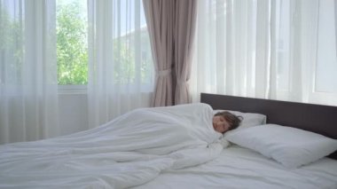 Bir erkek yatakta üşüdüğünü hisseder. Battaniyenin altında ısınmaya çalışıyor. humma kavramı