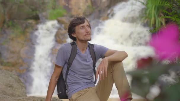 En ung man turist besöker vattenfall i bergen. Resor till Dalat-konceptet — Stockvideo