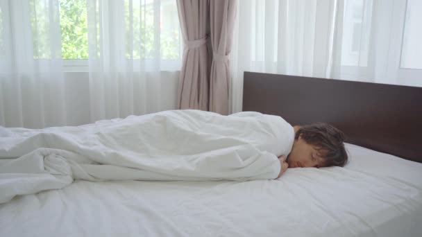 Zdrowy młody człowiek w łóżku czuje się świetnie po spaniu bez poduszki. — Wideo stockowe