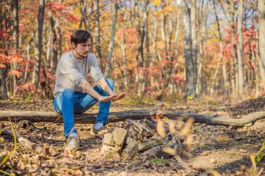 Adam ateşin başında ellerini ısıtıyor. Fakir adamlar açık havada sigara içilen barın yanında ısınıyor.