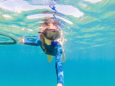 Tropik sularda şnorkelle yüzen genç kadınlar
