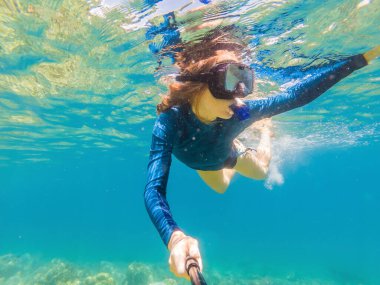 Tropik sularda şnorkelle yüzen genç kadınlar