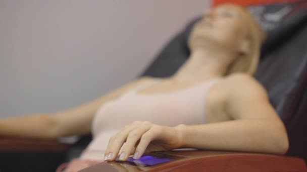 Colpo in mano di una giovane donna seduta su una sedia di massaggio automatico — Video Stock