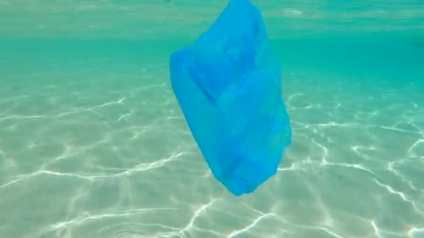 Colpo subacqueo di un uomo che raccoglie sacchetti di plastica nel bellissimo mare turchese. Paradiso inquinamento spiaggia. Il problema della spazzatura sulla sabbia della spiaggia causata dall'inquinamento causato dall'uomo. Campagne ecologiche — Video Stock