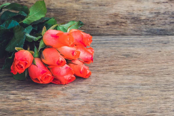 Красные розы на старом деревянном столе — стоковое фото