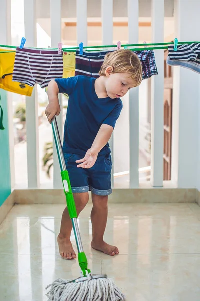 Pojken städar, tvättar golvet med mopp. Liten hemhjälp — Stockfoto